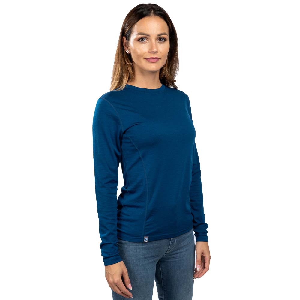 Frau in Merino Langarmshirt Damen 150 g/m², ideal für Outdoor-Aktivitäten, zeigt das ultraleichte, atmungsaktive Design aus temperaturregulierender Merinowolle.