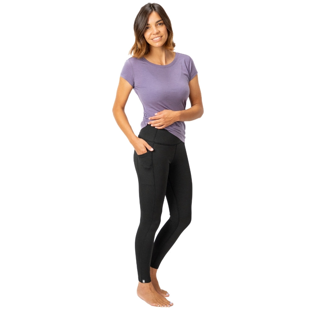 Frau trägt Merino Leggings/Hose Damen - 290 g/m2 mit Seitentaschen, ideal für Yoga und Reisen, bietet Bewegungsfreiheit und Komfort.