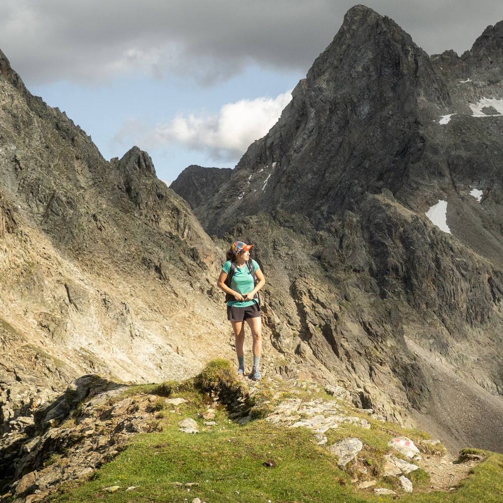 m2 auf einem grasbewachsenen Felsvorsprung vor schneebedeckten Bergspitzen, ideal für Outdoor-Aktivitäten und Temperaturanpassung.