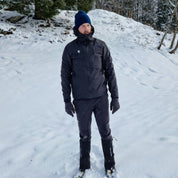 Person in schneebedeckter Landschaft trägt die Herren 3 Lagen Hardshell Regenjacke von Alpin Loacker, ideal für Outdoor-Aktivitäten durch wasserdichte, winddichte und atmungsaktive Eigenschaften.