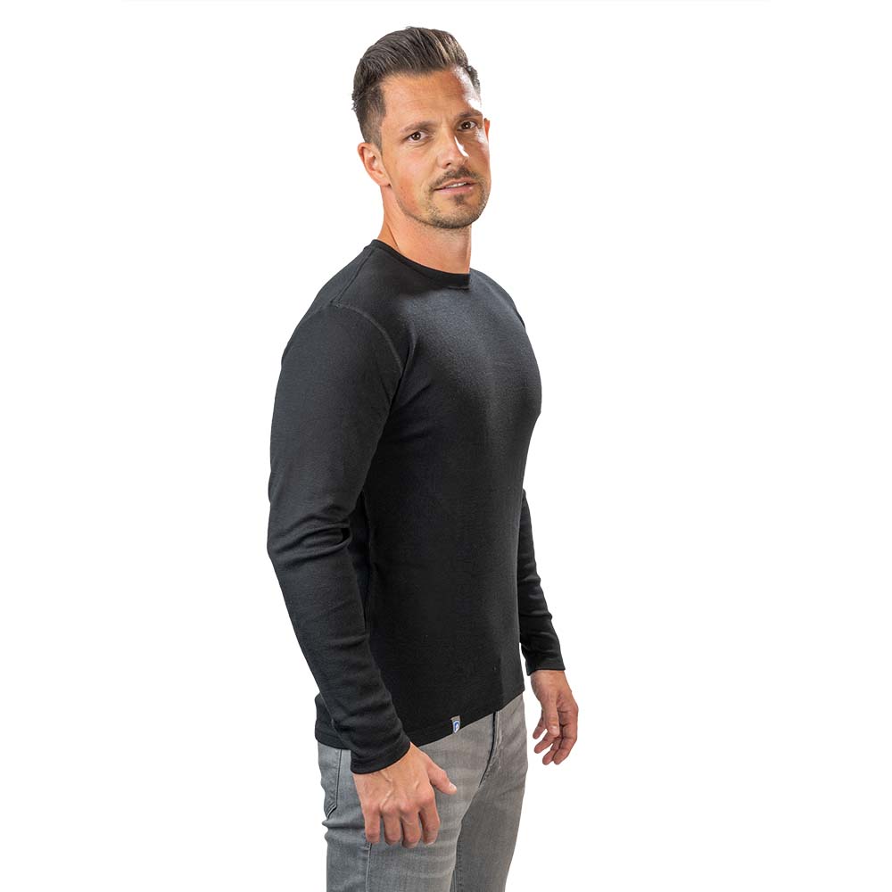 Mann trägt das Merino Langarmshirt Herren 230 g/m2 von Alpin Loacker, ideal für Outdoor-Aktivitäten, aus 100% Merinowolle, geruchsneutral und schnelltrocknend.