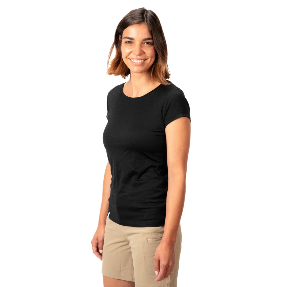 Junge Frau im 100% Merino T-Shirt Damen 160 g/m²- ultrafein, ideal für Outdoor-Aktivitäten, steht entspannt vor weißem Hintergrund.