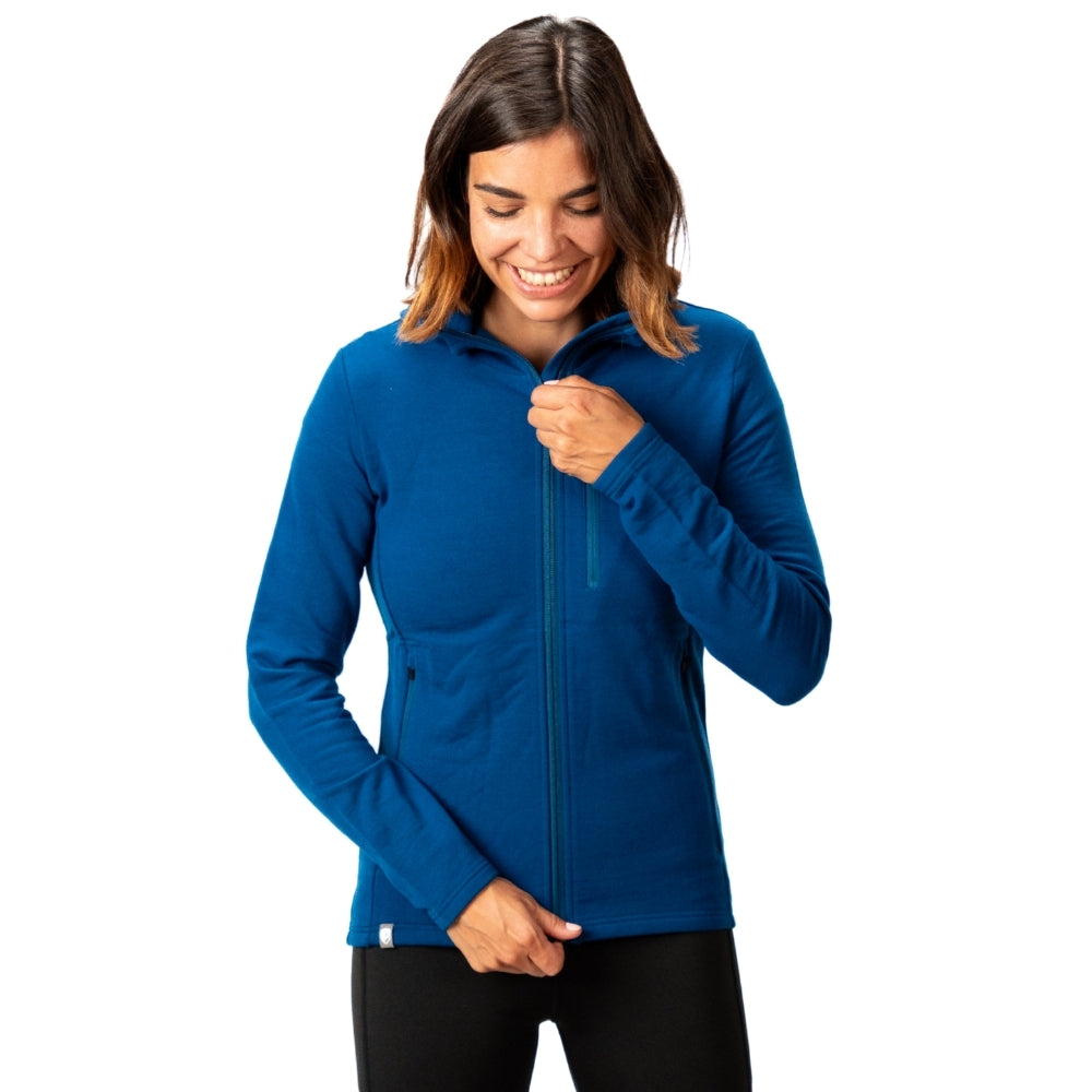 Frau trägt Merino Hoody Damen - 270g/m2 mit Reißverschluss und Taschen, ideal für Outdoor-Aktivitäten bei kühlem Wetter.