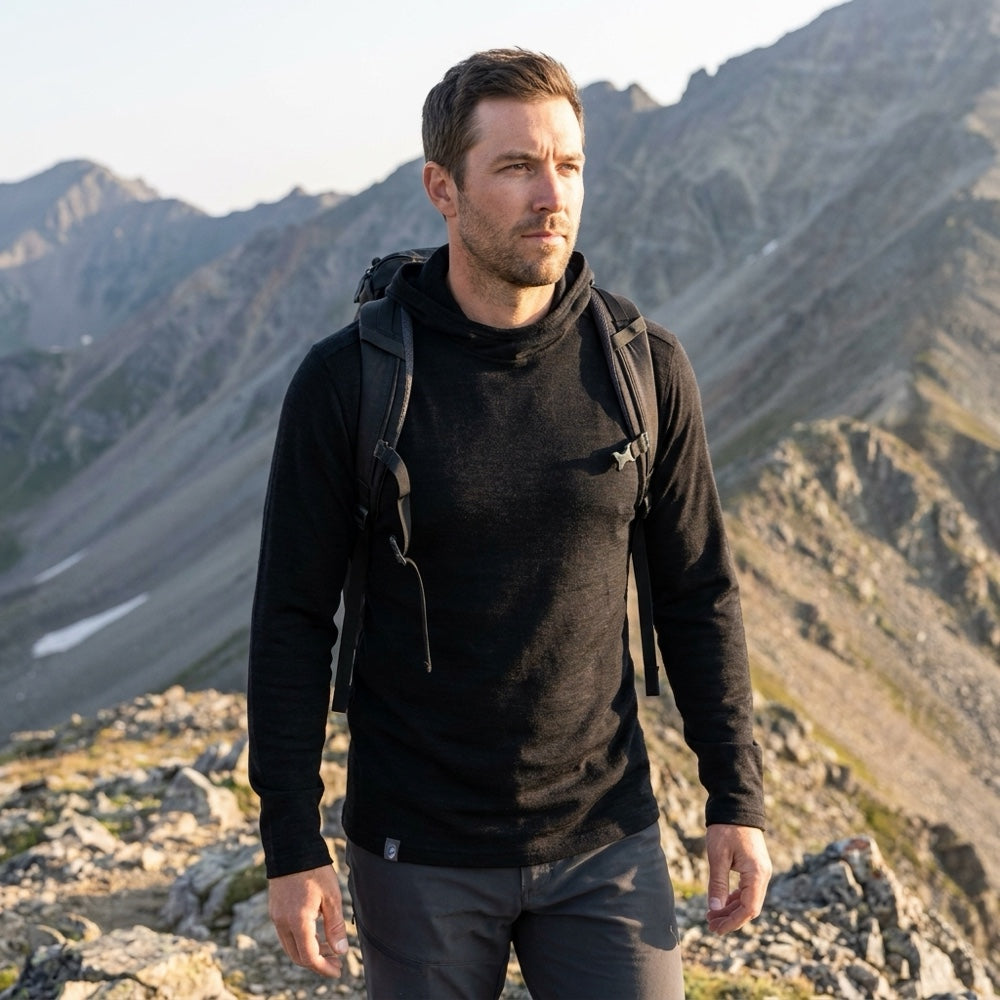 Mann auf Bergtour im schwarzen Merino Hoodie Herren 230 g/m² von Alpin Loacker