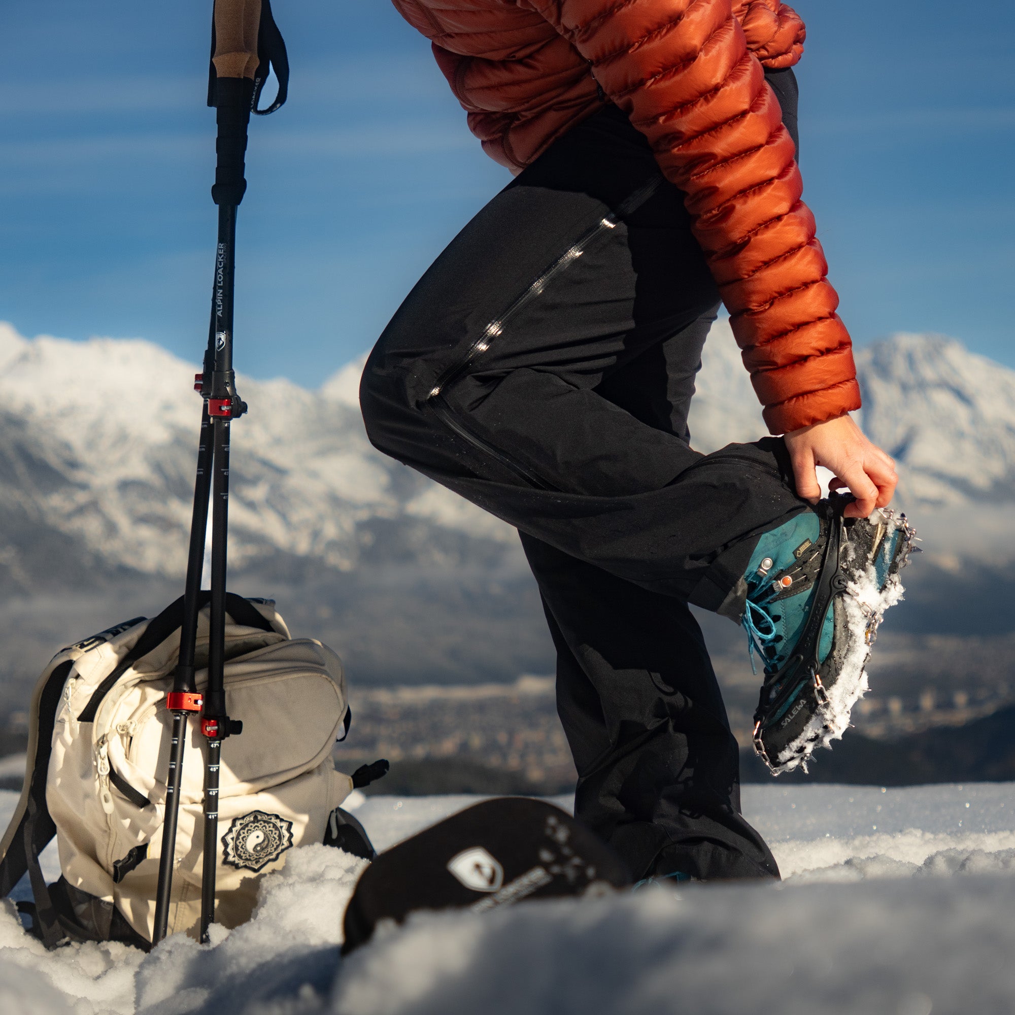 Dame zieht sich die Chain Pro 18 Grödel an für ihre Winterwanderung im Schnee