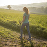 Frau mit Teleskop Nordic Walking Stöcken aus Aluminium von Alpin Loacker im Feld, zeigt ergonomische Korkgriffe und verstellbare Länge für optimalen Komfort.