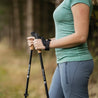 Frau im Wald mit Teleskop Nordic Walking Stöcken aus Aluminium von Alpin Loacker, ergonomische Korkgriffe und verstellbare Länge für vielseitiges Outdoor-Erlebnis.