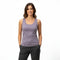 Model steht vor weißem Hintergrund da und trägt ein Merino Tank Top in der Farbe Violet. 