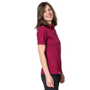 Model lacht im Studio und trägt Merino Coolmax Polo in Farbe Berry von Alpin Loacker
