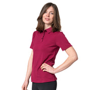 Model steht im Studio und trägt Merino Coolmax Polo in Farbe Berry von Alpin Loacker