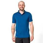 Model posiert in blauem Merino Coolmax Polo vor weißem Hintergrund