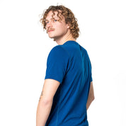 Männliches Model trägt Merino V-Neck T-Shirt Herren in blau, perfekt für Outdoor-Aktivitäten, vor weißem Hintergrund