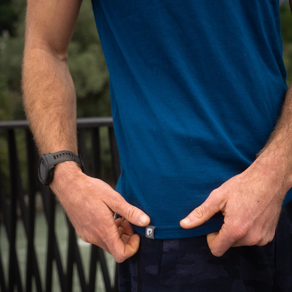 Nahaufnahme eines blauen Merino Coolmax T-Shirts, welches zurecht gezogen wird