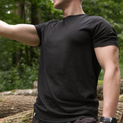 Mann steht mit schwarzem Merino Coolmax TShirt in der Natur