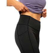 Person trägt Merino Leggings/Hose Damen - 290 g/m2 mit hohem Bund und Seitentasche, passend für Outdoor-Aktivitäten.