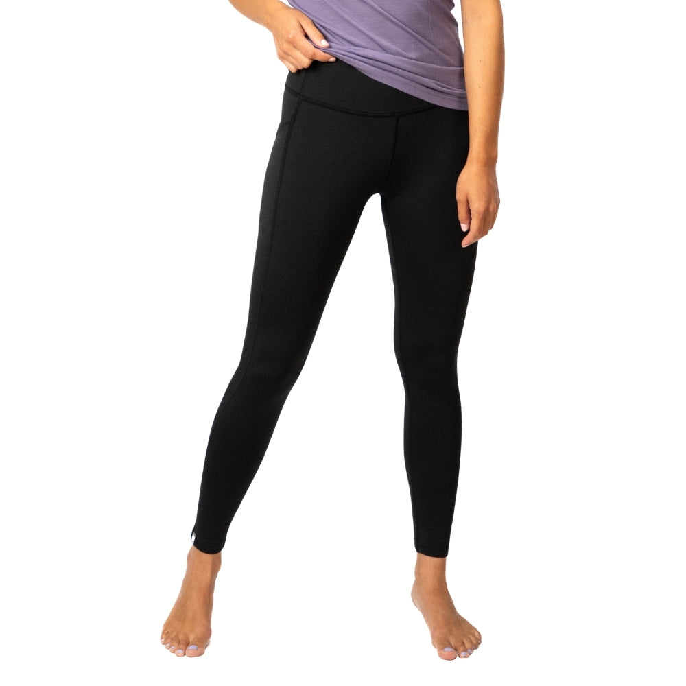 Merino Leggings/Hose Damen - 290 g/m2: Figurbetonte schwarze Leggings mit hohem Bund und Seitentasche, ideal für Yoga und Reisen, getragen mit lila Oberteil.