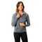 Junge Frau trägt 100% Merinowolle Jacke Damen 160 g/m² - ultrafein, ideal für Outdoor-Abenteuer, über lila T-Shirt und schwarzen Leggings, lächelnd beim Zuziehen des Reißverschlusses.