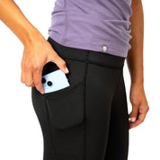 Nahaufnahme von Merino Leggings/Hose Damen - 290 g/m2 mit seitlicher Tasche, in die ein Smartphone gesteckt wird, ideal für Yoga, Alltag und Reisen.