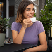 Frau sitzt in einem Cafe mit flieder farbenem Merino Shirt, perfekt für Alltags und Sport