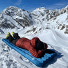 Light sleeping mat for 4 seasons: Person lying on the R5 pad from Alpin Loacker in the snow, ideal for winter adventures, excellent insulation, comfortable design.