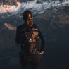 Femme avec un sac à dos ultraléger et étanche Lotus 25 2.0 en randonnée en montagne. Parfait pour les aventures en plein air avec un grand espace de rangement et un design robuste.