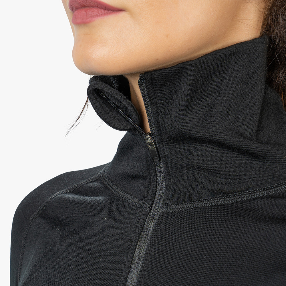 Nahaufnahme eines Merino Langarmshirts mit Zip Damen 230g/m², betont Reißverschluss-Detail und Funktionalität für Outdoor-Abenteuer, aus weicher, geruchsresistenter Merinowolle.