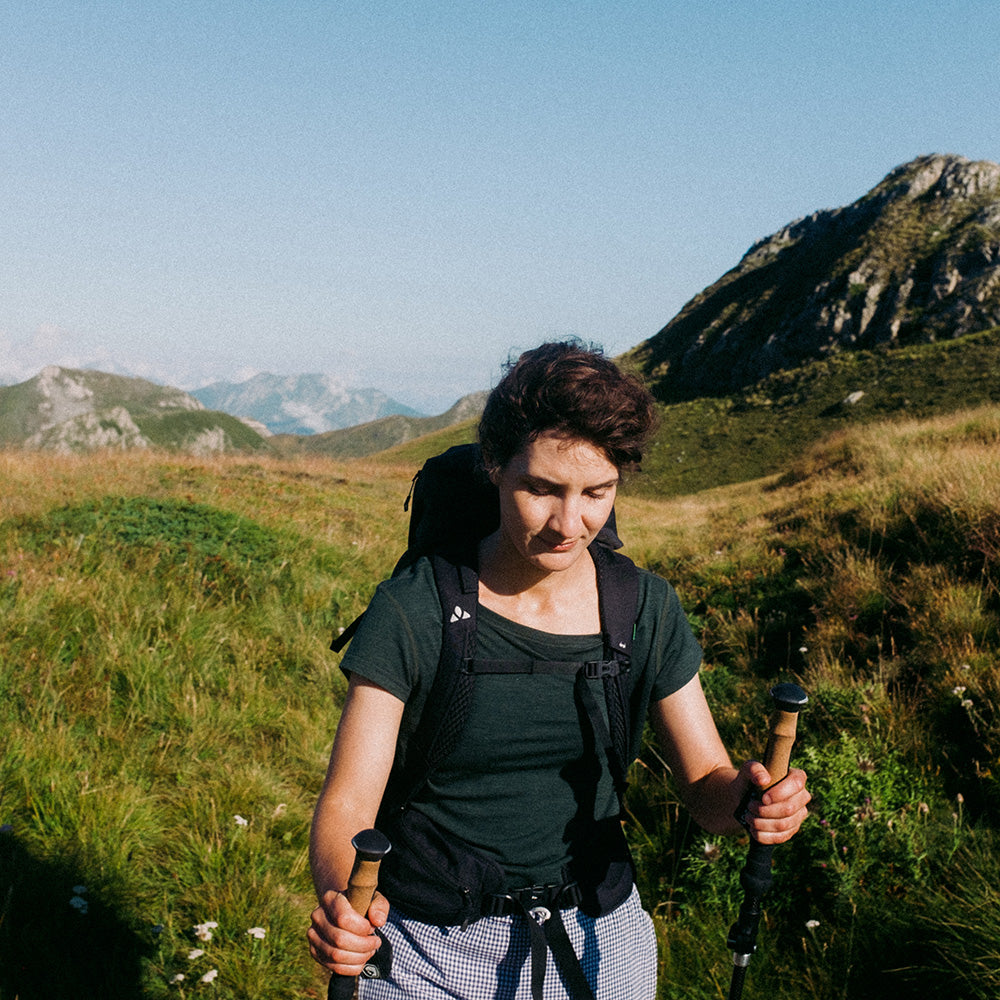 Frau wandert mit Merino T-Shirt Damen 150g/m2 von Alpin Loacker, ideal für Outdoor-Aktivitäten dank Corespun-Merinowolle für Komfort und Strapazierfähigkeit.