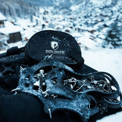 Chain Pro 18 Grödeln auf schwarzem Rucksack mit Schneeschuhen, ideal für sicheren Halt auf Schnee und Eis. Enthält 18 Spikes und praktische Aufbewahrungstasche.