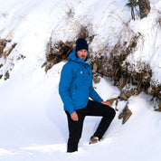 Mann trägt Herren 3 Lagen Hardshell Regenjacke im Schnee, ideal für Outdoor-Aktivitäten dank wasserdichter, winddichter und atmungsaktiver Eigenschaften. Perfekt für Alpinabenteuer.