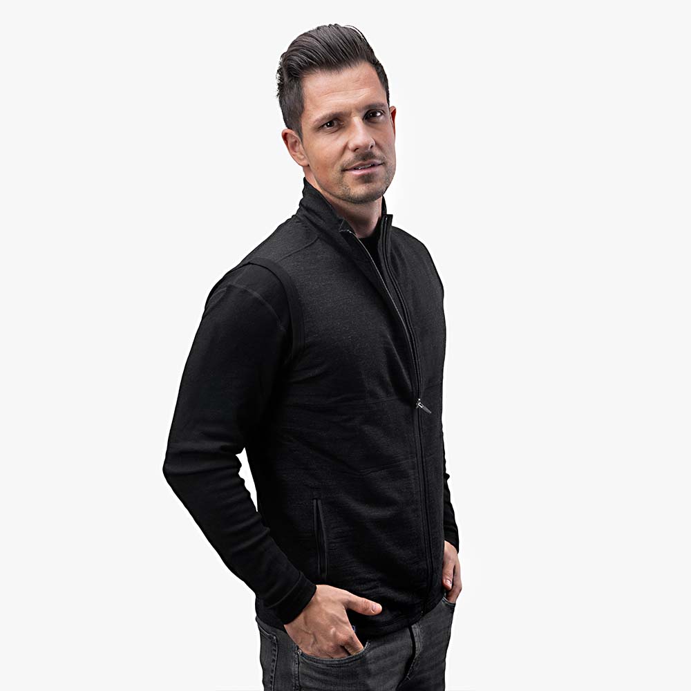 Merino Weste Herren 270 g/m² getragen von einem Mann, zeigt klassische Passform und praktische Seitentaschen, ideal für Outdoor-Aktivitäten, passend als Midlayer bei kühlem Wetter.