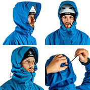 Mann trägt ultraleichte Herren 3 Lagen Hardshell Regenjacke mit helmkompatibler Kapuze, ideal für Outdoor-Aktivitäten wie Klettern und Skitouren.