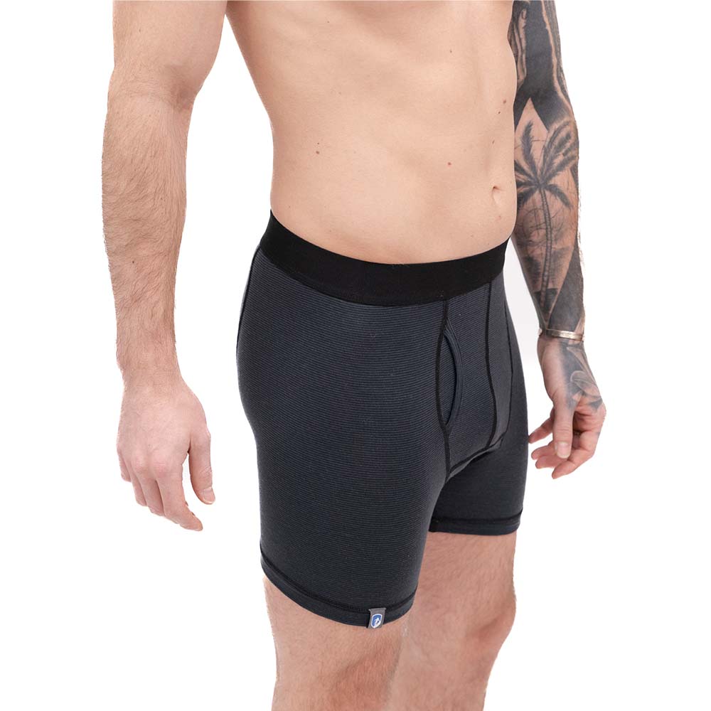 Mann trägt Merino Boxershorts Herren 150 g/m², ideal für Outdoor-Abenteuer, mit CORESPUN-Technologie für Haltbarkeit und Komfort. Perfekt für Sport und Alltag.
