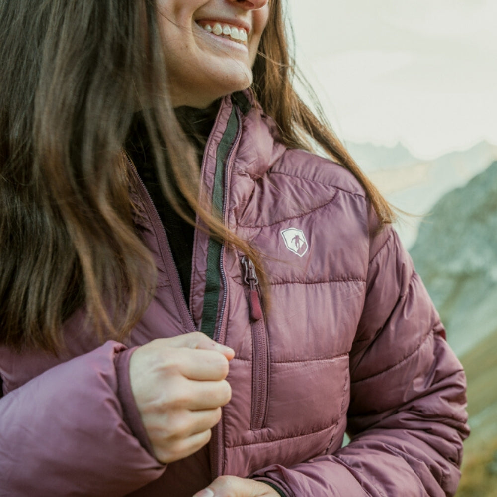 Frau trägt warme Isolationsjacke Damen mit Wollfutter, ideal für Herbst und Winter, mit recycelten Materialien und integriertem Packsack, geeignet für Outdoor-Aktivitäten.