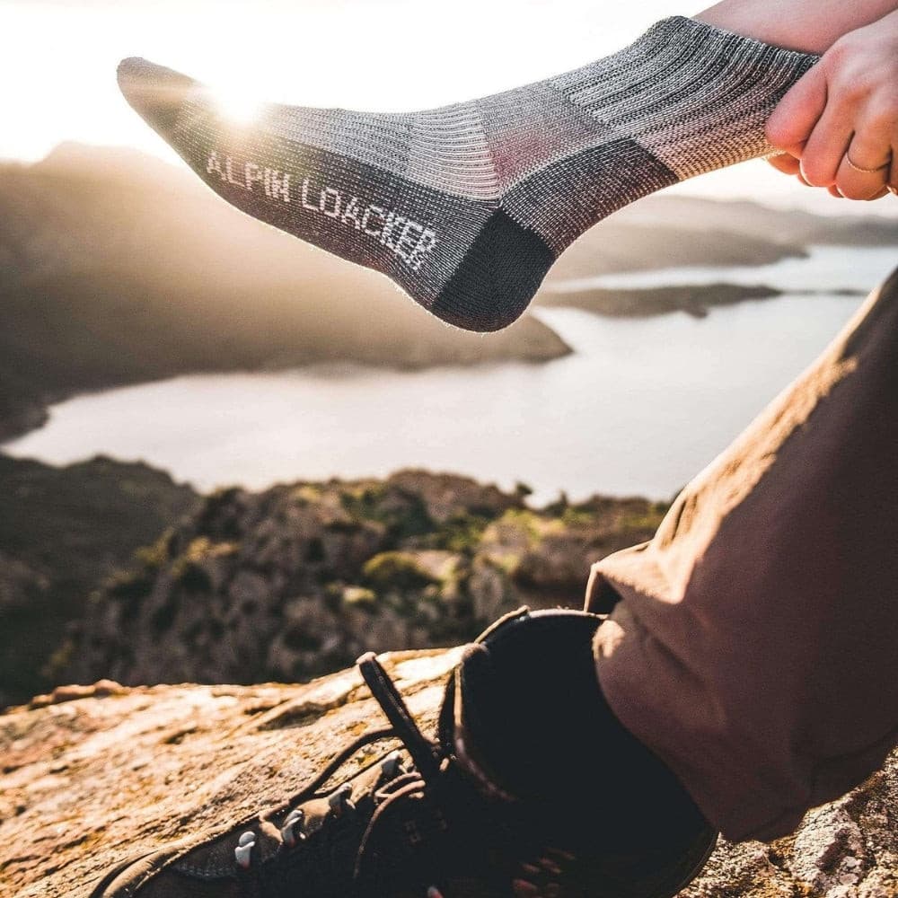 Person hält Merino Wandersocken Classic Herren & Damen, ideal für Outdoor-Abenteuer, aus 72% Merinowolle für Komfort und Strapazierfähigkeit. Perfekt für Wanderungen und Trekking.