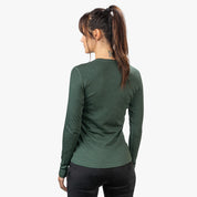 Frau trägt Merino Langarm Shirt Damen 230 g/m2, ideal für Outdoor-Aktivitäten, aus 100% Merinowolle mit geruchsneutralen, temperaturregulierenden Eigenschaften.