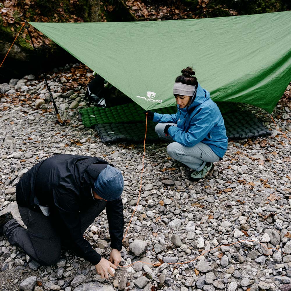 Ultra leichte Isomatte - 465g neben einem Zelt im Freien, mit Personen beim Camping; ideal für Trekking und Outdoor-Abenteuer.