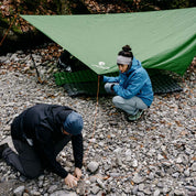 Ultra leichte Isomatte - 465g neben einem Zelt im Freien, mit Personen beim Camping; ideal für Trekking und Outdoor-Abenteuer.