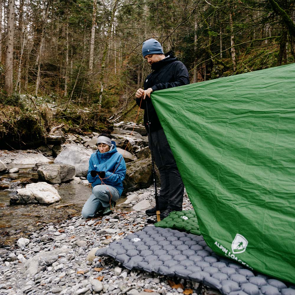 Mann und Frau stehen neben einem Zelt mit der ultra leichten Isomatte - 465g, ideal für Camping und Outdoor-Abenteuer.
