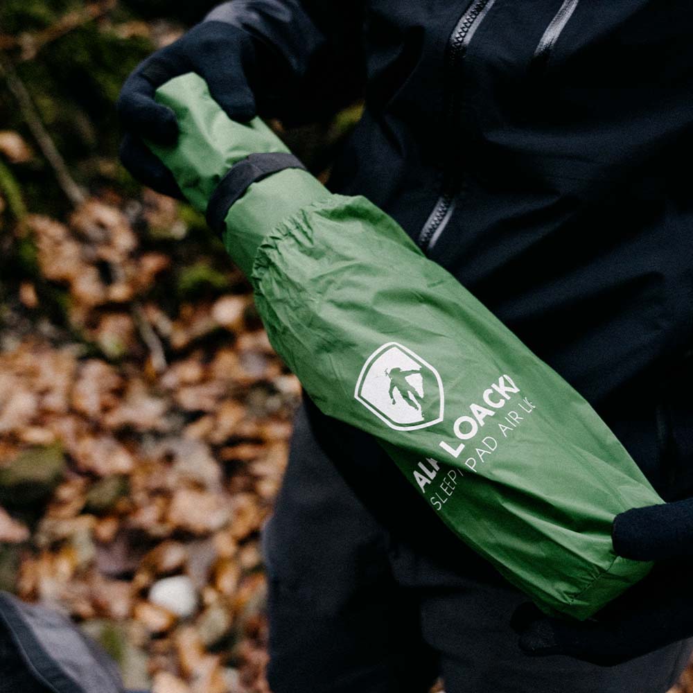 Person hält die ultraleichte Isomatte - 465g, ideal für Camping und Trekking, kompakt und aus 100% recyceltem RipStop Nylon gefertigt.