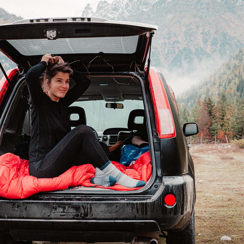 Frau entspannt im Auto, trägt Merino Wandersocken Classic Herren & Damen von Alpin Loacker, ideal für Outdoor-Aktivitäten und Wanderungen.