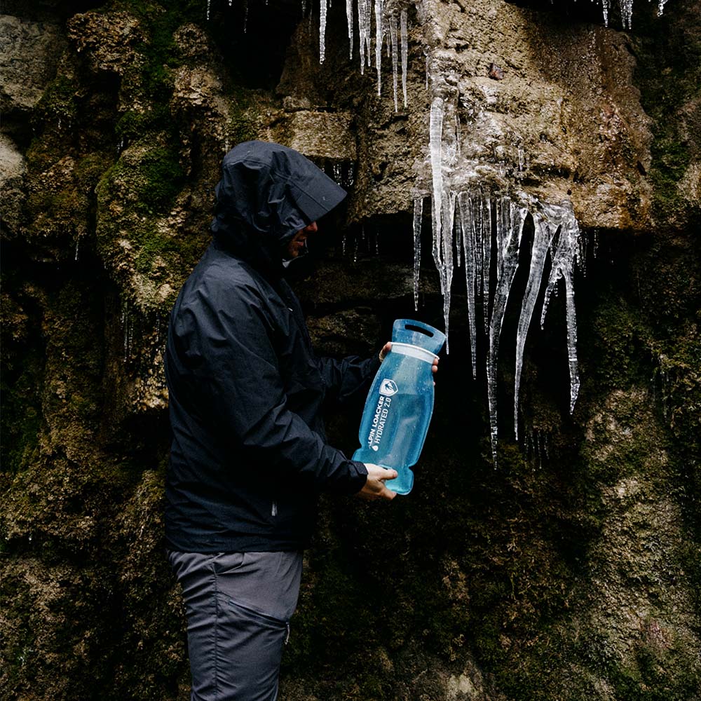 Trinkblase für Sommer + Winter, gehalten von einer Person neben Eiszapfen; ideal für Outdoor-Aktivitäten, ultraleicht, robust und auslaufsicher.